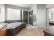Bathroom featuring a soaking tub, glass-enclosed shower, and vanity with countertop space and ample lighting at 6040 Virgil St, Arvada, CO 80403