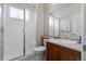 Bright bathroom featuring a glass-enclosed shower, vanity with cabinet storage, and neutral tile flooring at 6040 Virgil St, Arvada, CO 80403