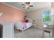 Well-lit bedroom with a ceiling fan, complemented by an adjacent desk and a window overlooking lush greenery at 6040 Virgil St, Arvada, CO 80403