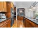 Open kitchen with stainless steel appliances, wood cabinets, and a large island for extra prep space at 6040 Virgil St, Arvada, CO 80403