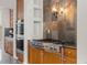 Gourmet kitchen featuring stainless steel appliances, granite countertops, and a stylish tile backsplash at 6040 Virgil St, Arvada, CO 80403