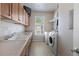 Functional laundry room equipped with a sink, generous counter space, and modern washer and dryer at 6040 Virgil St, Arvada, CO 80403