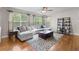 Bright living room featuring a comfortable gray sofa, wood floors, and a decorative ceiling fan at 6040 Virgil St, Arvada, CO 80403