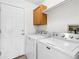 Laundry room featuring white washer and dryer units, and a mounted wooden cabinet at 12776 Yates Cir, Broomfield, CO 80020