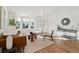 Bright living room with a large bay window, brown leather couch, modern furniture, and light wood flooring at 12776 Yates Cir, Broomfield, CO 80020