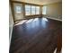 Bright living room featuring hardwood floors, a row of windows, and a glass door at 10712 Dayton Way, Commerce City, CO 80640