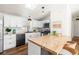 Modern kitchen with white cabinets, geometric backsplash, and a large island at 3407 W Arkansas Ave, Denver, CO 80219