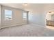 A carpeted bedroom features two windows with views and an ensuite bathroom with double sinks at 798 Sawdust Dr, Brighton, CO 80601