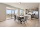 Dining area with a wooden table, gray chairs, sliding glass doors to the patio, and an open kitchen concept at 798 Sawdust Dr, Brighton, CO 80601