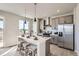 Modern kitchen with stainless steel appliances, gray cabinets, a white countertop island, and pendant lighting at 798 Sawdust Dr, Brighton, CO 80601