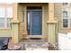 Close-up of a blue front door with rocking chair on a covered front porch at 3578 Tranquility Trl, Castle Rock, CO 80109