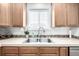 A kitchen sink and window, surrounded by light countertops and wooden cabinetry at 3578 Tranquility Trl, Castle Rock, CO 80109
