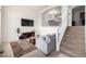 Cozy living room with a comfortable gray couch, stairway, and a view of the dining area at 3578 Tranquility Trl, Castle Rock, CO 80109