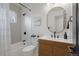 Modern bathroom with white tile, a sleek vanity with wooden accents, and stylish black fixtures at 3379 Krameria St, Denver, CO 80207