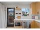 The kitchen features bright cabinetry, stainless steel appliances and fixtures, and an exterior door to the backyard at 3379 Krameria St, Denver, CO 80207