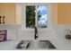 The kitchen sink boasts modern fixtures and bright natural light from the window overlooking the outdoor view at 3379 Krameria St, Denver, CO 80207