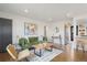 Bright living room featuring hardwood floors, modern decor, a comfortable green sofa, and stainless steel appliances at 3379 Krameria St, Denver, CO 80207