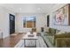 Inviting living room with hardwood floors, green sofa, and a large window offering natural light at 3379 Krameria St, Denver, CO 80207
