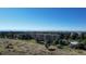 Community aerial showcasing multiple buildings, expansive fields, and mountain views under a clear, blue sky at 13952 E Marina Dr # 509, Aurora, CO 80014