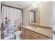 Bathroom with floral shower curtain, wood cabinets, and a clean, functional design at 13952 E Marina Dr # 509, Aurora, CO 80014