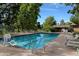 Outdoor swimming pool with clear water, lounge chairs, mature trees, and nearby building for residents' relaxation at 13952 E Marina Dr # 509, Aurora, CO 80014