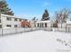 Spacious backyard with a shed, fence, and deck accessible via stairs. A blanket of snow covers the ground at 9135 W Maplewood Ave, Littleton, CO 80123