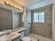 Bright bathroom featuring a shower over the tub and a large mirror with vanity lighting at 9135 W Maplewood Ave, Littleton, CO 80123