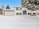 Charming split-level home with a two-car garage and snow-covered front yard at 9135 W Maplewood Ave, Littleton, CO 80123