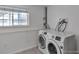 Bright laundry room with a large window and modern, front-loading washing machine and dryer at 9135 W Maplewood Ave, Littleton, CO 80123