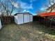 Backyard shed offers extra storage, complemented by a privacy fence and a clear blue sky at 9135 W Maplewood Ave, Littleton, CO 80123