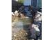 Water feature with rocks and a small waterfall, adding a serene and natural element to the landscape at 9135 W Maplewood Ave, Littleton, CO 80123