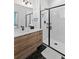 Modern bathroom with a walk-in shower, hex tile flooring, and a light wood vanity at 3553 W 63Rd Ave, Denver, CO 80221