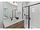 Modern bathroom with a walk-in shower and wood vanity at 3553 W 63Rd Ave, Denver, CO 80221