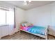 This bedroom has a colorful bedspread, wood floors, and plenty of natural light from the window at 5106 Eagle Ct, Denver, CO 80239