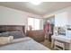 This bedroom has a gray bed set, wood floors, and a vanity desk with a mirror at 5106 Eagle Ct, Denver, CO 80239