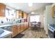 Bright kitchen featuring a dining area, wooden cabinets, stainless steel appliances, and a tiled floor at 5106 Eagle Ct, Denver, CO 80239