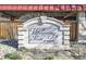 Stone entrance sign for Whispering Pines of Denver, with rock landscaping and attractive architectural details at 7755 E Quincy Ave # 203A2, Denver, CO 80237