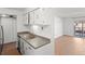 Updated kitchen with stainless steel appliances and a view to the living room and balcony at 7755 E Quincy Ave # 203A2, Denver, CO 80237