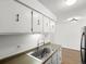Bright kitchen features stainless steel sink, white cabinetry, and modern faucet at 7755 E Quincy Ave # 203A2, Denver, CO 80237