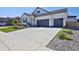 Bright exterior view showcasing a two-car garage, modern design, and landscaped front yard with drought resistant stone at 1160 Spencer Pl, Erie, CO 80026