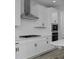 Close up showcasing white cabinets, an undermount microwave, and stainless steel range hood at 1160 Spencer Pl, Erie, CO 80026