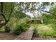 Backyard wooden walking bridge over a stream among lush landscaping and mature trees at 730 Crescent Ln, Lakewood, CO 80214