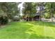 Expansive backyard with lush green lawn, mature trees, white fence, and gazebo perfect for entertaining at 730 Crescent Ln, Lakewood, CO 80214