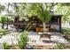 Backyard features a stone patio, hot tub, covered deck and landscaping, creating a serene outdoor living space at 730 Crescent Ln, Lakewood, CO 80214