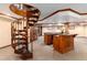 Finished basement with a spiral staircase leading to a bar area with wooden cabinets and granite countertops at 730 Crescent Ln, Lakewood, CO 80214