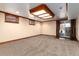 Spacious basement with neutral carpet, recessed lighting, and a door leading to the outside at 730 Crescent Ln, Lakewood, CO 80214