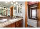 Well-lit bathroom featuring vanity with granite countertops and access to a separate tub and shower area at 730 Crescent Ln, Lakewood, CO 80214
