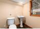 Cozy bathroom with a pedestal sink and dark tile floor next to a wood-trimmed window at 730 Crescent Ln, Lakewood, CO 80214