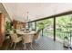 Covered deck features wood floors, a dining table, and black metal railing overlooking a lush yard at 730 Crescent Ln, Lakewood, CO 80214