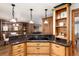 Bright kitchen featuring wood cabinets, granite countertops, cooktop, and a view into the living area at 730 Crescent Ln, Lakewood, CO 80214